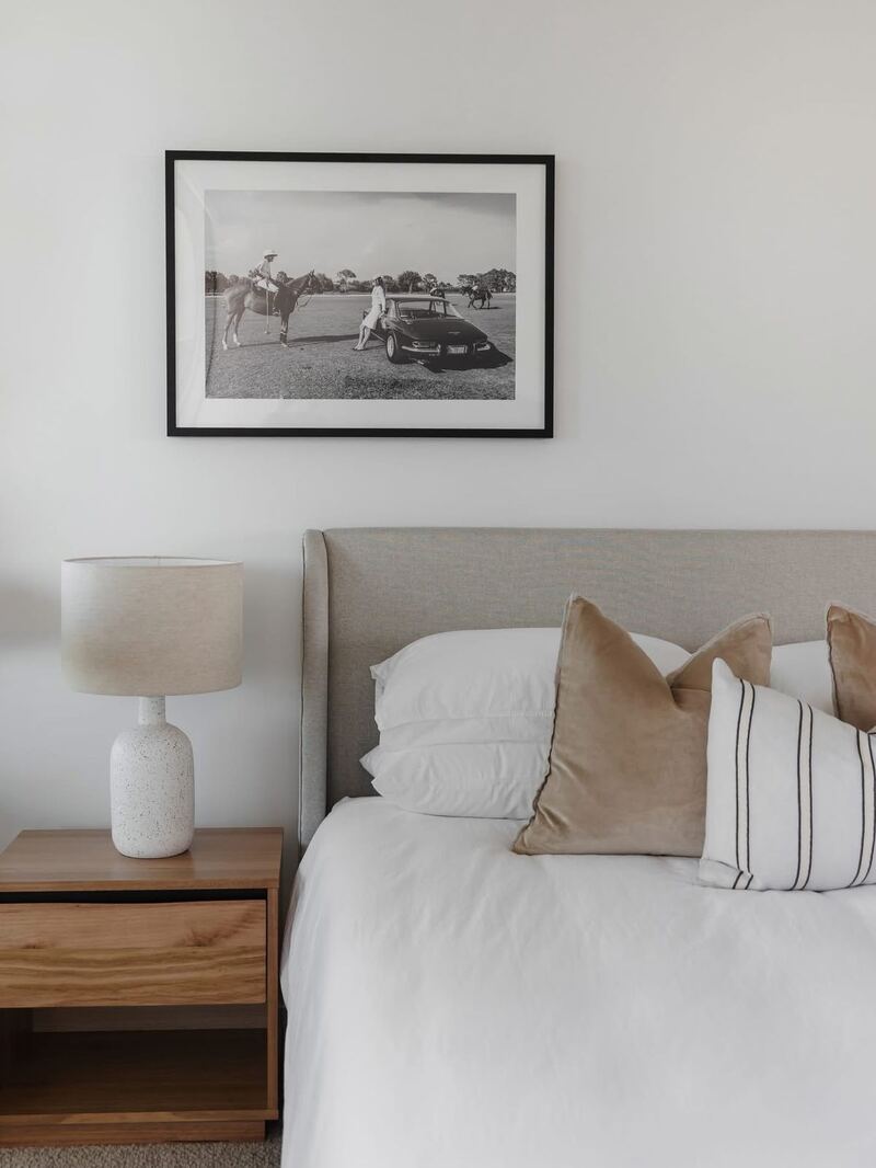 Artwork installation in a Brisbane bedroom by Cliff Hanger. Black framed equestrian photograph above a tailored linen bedhead.