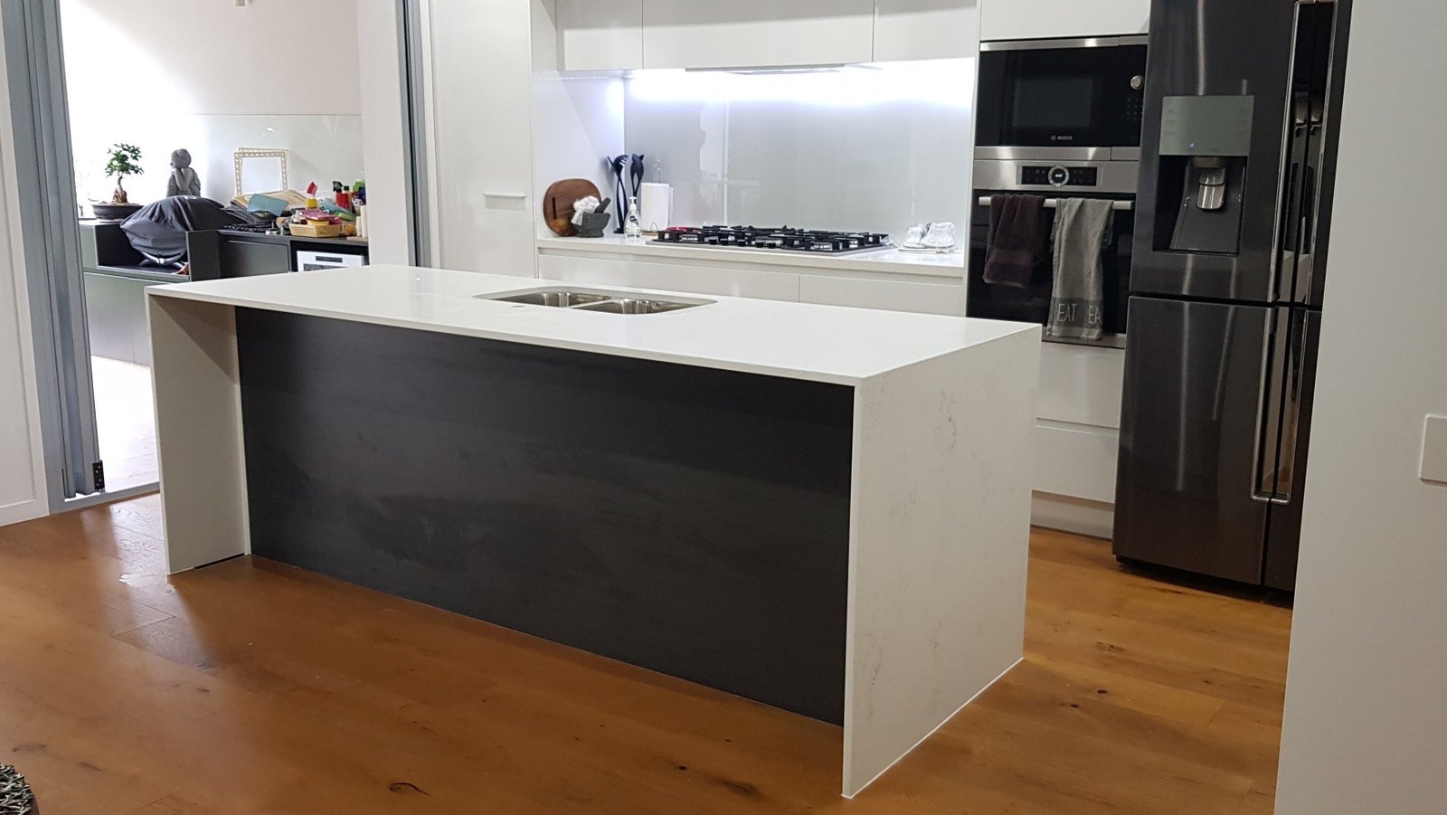 Before: kitchen island with a bare dark panel facing the living area.
