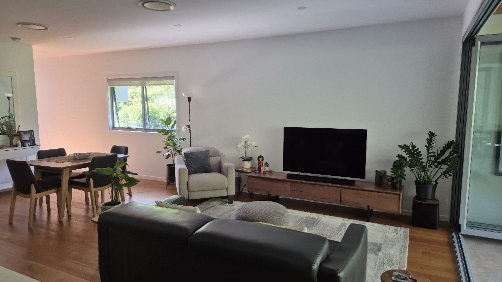 Before: TV mounted on a plain white wall, no decorative panel.