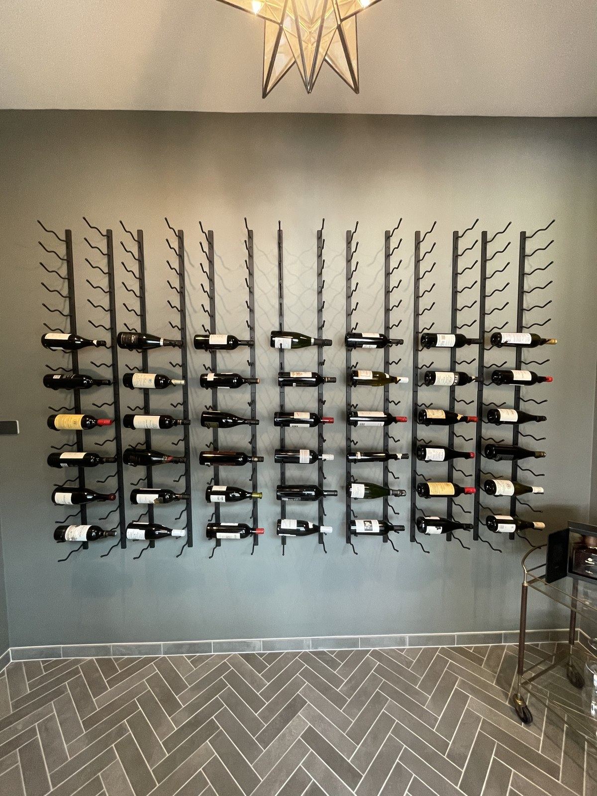 Wine cellar wall-mounted rack front view, fully populated with bottles.